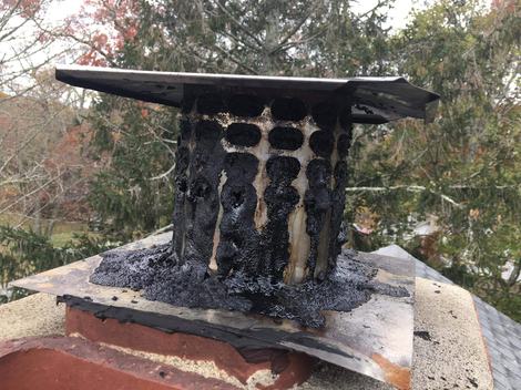 Thick glazed creosote and tar built up on a chimney cap and crown