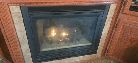 Gas fireplace insert with a tile surround and a low pilot flame