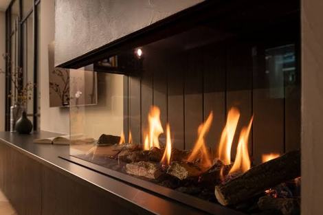 Contemporary linear gas fireplace with ceramic logs and a dark surround